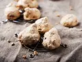Biscotti meringati, dall'aspetto rustico, brutti ma buoni, su una griglia metallica e un telo grezzo.