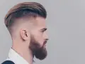 Mężczyzna z modnym irokezem i zadbaną brodą, stylizacja na rockmana.