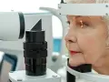 Starsza kobieta podczas badania wzroku, które może wykryć widzenie tunelowe.