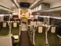 Wnętrze wagonu PKP Intercity. Puste zielone fotele czekają na pasażerów. Pamiętaj, że pkp intercity bilet bez gwarancji miejsca do siedzenia może oznaczać podróż na stojąco.