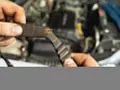 Zużyty pasek rozrządu w dłoni mechanika. Wymiana rozrządu jest kluczowa dla sprawnego działania silnika.