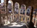 Dalla scala Contarini del Bovolo, vista sui tetti di Venezia. Colonne e archi in pietra creano un gioco d'ombre sulla gradinata.
