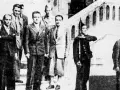 Groupe d'hommes en costume, dont Henri Frenay et François Mitterrand, posant devant un escalier.