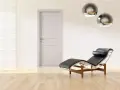 Divano in pelle nera e metallo, con un'elegante porta tortora e un muro con texture geometrica. Un perfetto abbinamento tortora e verde per un ambiente moderno.
