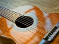 Klasyczna gitara, gotowa do wykonania znanych utworów na gitarę klasyczną. Jej drewniane, lśniące pudło rezonansowe zaprasza do muzycznej podróży.
