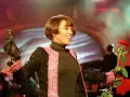 Whitney Houston z mikrofonem i czerwoną różą podczas niezapomnianego koncertu w Polsce.