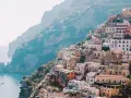 Colorful buildings cascade down a cliffside to the sea, a picturesque scene perfect for a 3 month Europe itinerary.