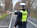 Policjant w kamizelce odblaskowej zatrzymuje ruch, by sprawdzić, ile promili ma kierowca.
