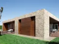 Moderna casa con facciate in pietra e inserti in legno. Un'oasi di design contemporaneo.