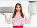 Donna sorridente mostra un condizionatore e un deumidificatore, utile per capire a quanto impostare il deumidificatore in inverno per un comfort ottimale.