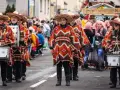 Menschen in bunten Ponchos und Sombreros marschieren mit Trommeln. Sie feiern Fasching, eine Zeit voller Freude und Verkleidungen.