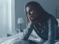 Zmartwiona kobieta siedzi w łóżku, zastanawiając się, nie mogę spać w nocy co robić.