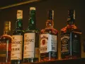 Rząd butelek whisky, w tym Laphroaig, Jim Beam i Jack Daniel's, idealny jako dobre whisky na prezent.