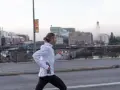 Man med hästsvans springer på en bro i Stockholm, klädd i adidas halvmarathon-kläder.