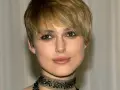 Primo piano di una donna con capelli biondi e tagli corti belli, trucco occhi marcato e un choker decorato.