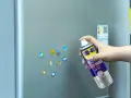 Jak usunąć naklejkę z szyby? Puszka WD-40 Sticker Remover w dłoni, gotowa do działania na lodówce.