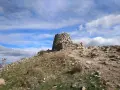 Ruinas de piedra en la cima del **cerro de San Pedro**, bajo un cielo azul con nubes blancas.
