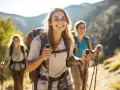 Uśmiechnięte kobiety podczas trekkingu w górach, cieszące się wędrówką.