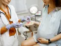 Lekarka podaje ciężarnej pacjentce lek. Rozmowa o upławach w ciąży.