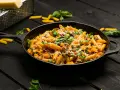 Makaron penne z mięsem mielonym i ziołami w żeliwnej patelni.