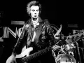 Sid Vicious, Punk-Ikone, spielt Bass auf der Bühne. Seine wilden Haare und Lederjacke unterstreichen seine rebellische Ausstrahlung. Seine Musik erfüllt die "sid wishes" des Publikums.