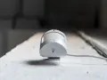 Detector de presencia y movimiento blanco, con cable, montado en superficie rugosa.