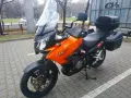Pomarańczowy motocykl turystyczny Kawasaki KLV 1000 z kuframi, gotowy na przygodę.
