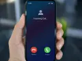 Dłoń trzyma smartfon z ekranem "Incoming Call...". Czy to połączenie z zagranicy, gdy działa co to roaming?