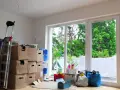 Umzugskartons stapeln sich neben einer Leiter. Es sieht aus, als ob jemand seine Sachen nicht abholt, rechtzeitig für den Umzug.