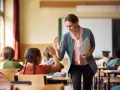 Uśmiechnięta nauczycielka daje piątkę uczennicy. To pozytywna ocena pracy nauczyciela początkującego, który buduje relacje z uczniami.