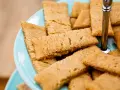 En hög med gyllene kolakakor på en ljusblå bricka. Perfekt för ett enkelt kolakakor recept.