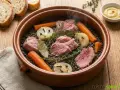 Palette demi-sel mijotant avec des lentilles, carottes, oignons cloués et herbes. Le temps de cuisson à l'eau est presque terminé.