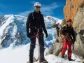 Zwei Bergsteiger auf dem Weg zur Mont Blanc Besteigung, umgeben von Schnee und Felsen.
