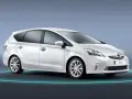 Biały Toyota Prius+ na tle niebieskim. To auto hybrydowe, które oferuje przestronne wnętrze, idealne dla rodziny. Ile miejsc ma ten model?