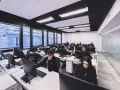 Giovani studenti concentrati davanti ai computer, un'aula moderna che ospita un corso di programmazione gratis.