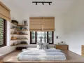 Habitación con cama baja, estanterías de madera y persianas de bambú. Un ejemplo de estilos de habitaciones minimalistas y acogedoras.