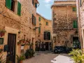 Urokliwa uliczka w Valldemossa. Zobacz kamienne domy z zielonymi okiennicami i mnóstwo kwiatów. Idealne miejsce na spacer i odkrywanie uroków miasteczka.
