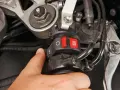 Il motorino gira ma la moto non parte. Il pollice preme il pulsante di accensione, ma il motore resta muto.