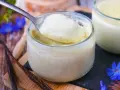 Délicieuse crème vanille recette, onctueuse et parsemée de grains de vanille, servie dans un pot en verre.