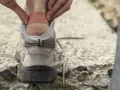 Application d'un pansement sur une ampoule au talon, une étape clé pour savoir comment soigner une ampoule au pied et continuer sa marche.