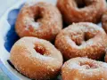 Rosquillas caseras de toda la vida, doradas y espolvoreadas con azúcar, listas para disfrutar.
