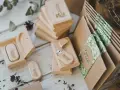 Drewniane pendrive'y z grawerem "Wedding" i koperty z motywem roślinnym. Personalizowane upominki dla gości od pary młodej to klucz do sukcesu.
