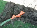 Tubi arancioni a Y e un tubo verde in una trincea: il sistema per capire come drenare il terreno.