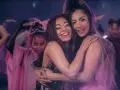 Ariana Grande i Lady Gaga przytulają się, otoczone tańczącymi ludźmi w różowych strojach. Czuć, że na nich "rain on me".