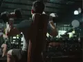 Två män tränar axlar med hantlar på ett gym. En fokuserar på push, den andra på pull.