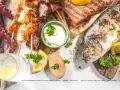 Un'abbondante grigliata di pesce con polpo, gamberi, calamari, aragosta e pesce intero, guarnita con limone e prezzemolo.