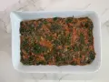 Lasaña de espinacas en salsa de tomate en un plato blanco.