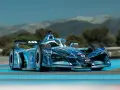 Coche de Fórmula E Gen 4 azul con diseño futurista, listo para la carrera en un día soleado.