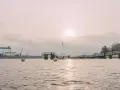 Kiel im Winter: Hafenkräne und eine Mole im nebligen Licht. Bojen treiben auf dem ruhigen Wasser.