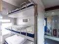 Wygodne łóżka w regiojet wagon sypialny. Trzy piętrowe prycze z pościelą czekają na podróżnych.